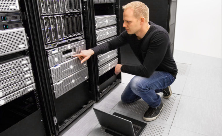 It engineer or consultant working with laptop and maintaining servers in data center.